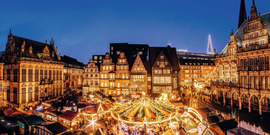 Beleuchtete Buden und ein Karussell auf dem Bremer Marktplatz zur Weihnachtszeit.
