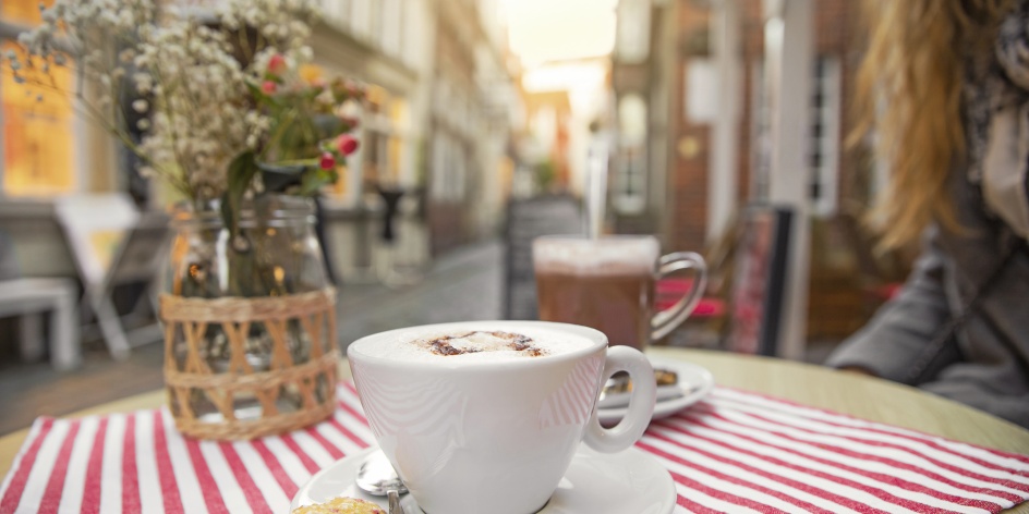 In the foreground are two cups on a table. In the background is the Schnoor quarter. 