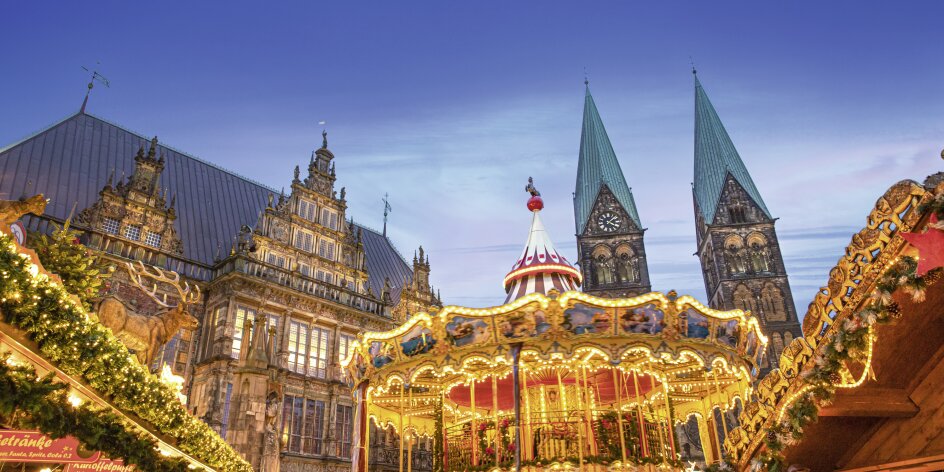Carousel at the Christmas market. Old buildings on the market square can be seen in the background. 