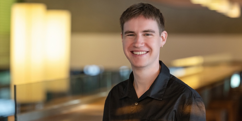 Porträtfoto eines lächelnden Mannes vor Tischen