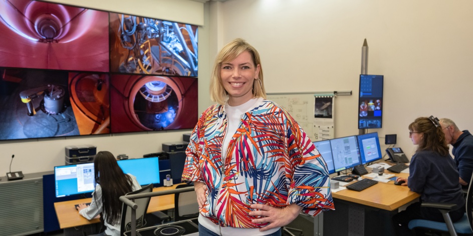 Eine Frau, die vor Monitoren steht, auf denen Experimente durchgeführt werden.