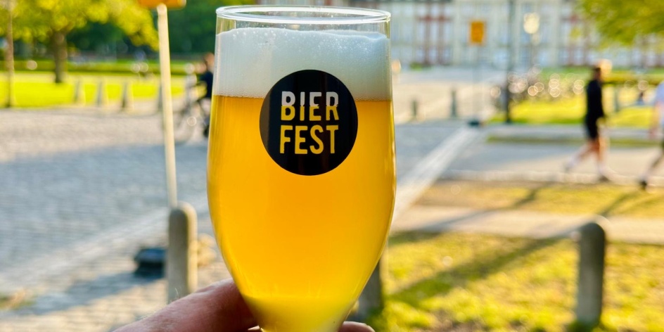Eine Hand hält ein Glas Bier, auf dem der Schriftzug Bierfest steht.