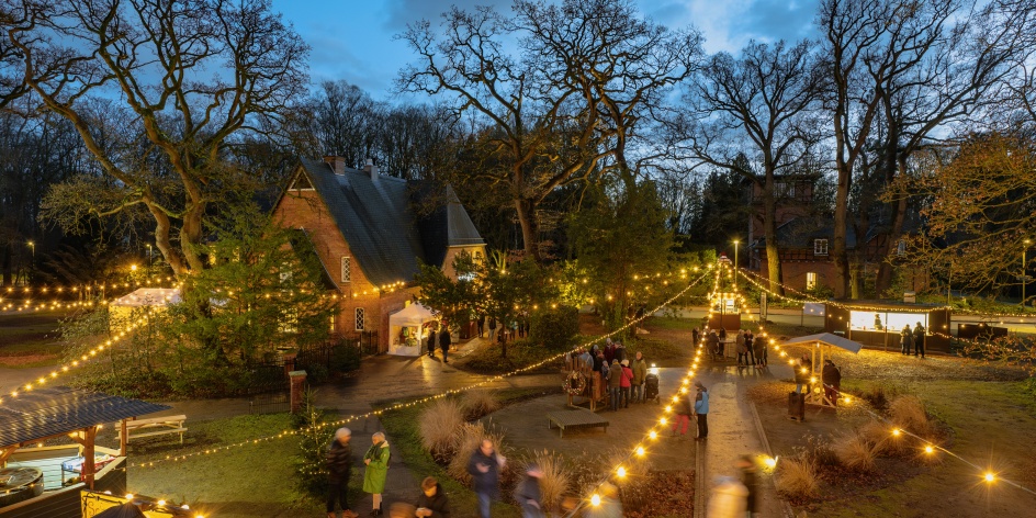Der Weihnachtszauber Kränholm bei Nacht. Lichterketten sind über den Markt gespannt.