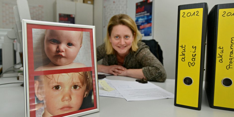 Eine Frau am Schreibtisch mit Kinderfotos.