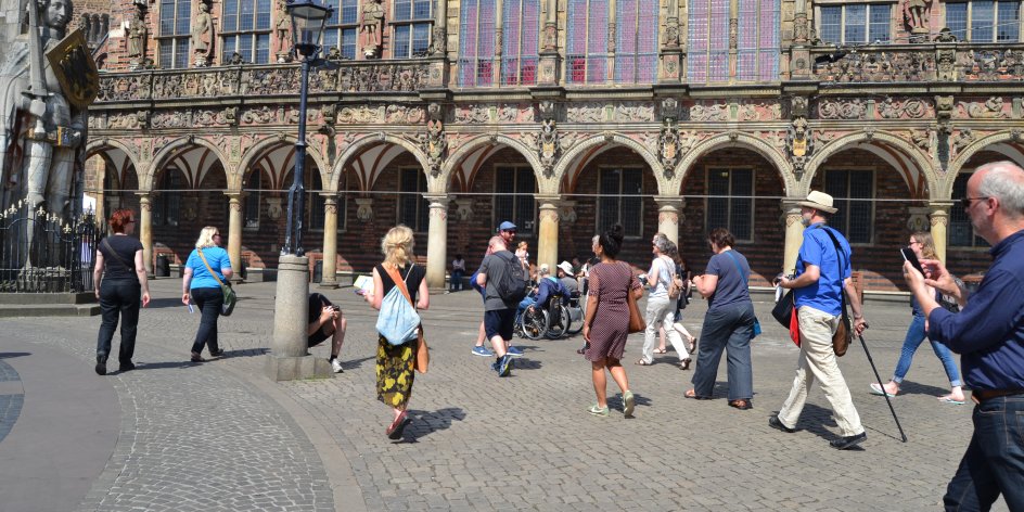 Die Teilnehmerinnen und Teilnehmer beim Start des Instawalk 'n' Roll auf dem Bremer Marktplatz, im Hintergrund das Rathaus.