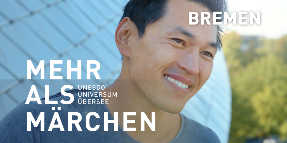 Ein lachender Mann vor dem Science Center Universum Bremen. Er hat schwarze Haare. Schriftzug im Bild: "Bremen - Mehr als Märchen. Unesco, Universum, Übersee". 