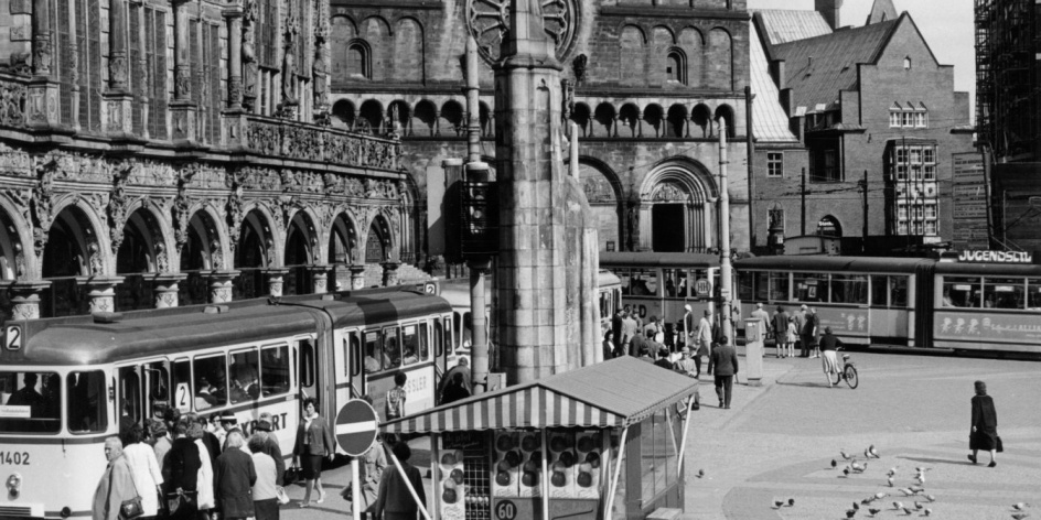 Eine alte schwarz-weiß Aufnahme vom Bremer Marktplatz. Es sind das Rathaus und der Roland zu sehen. 