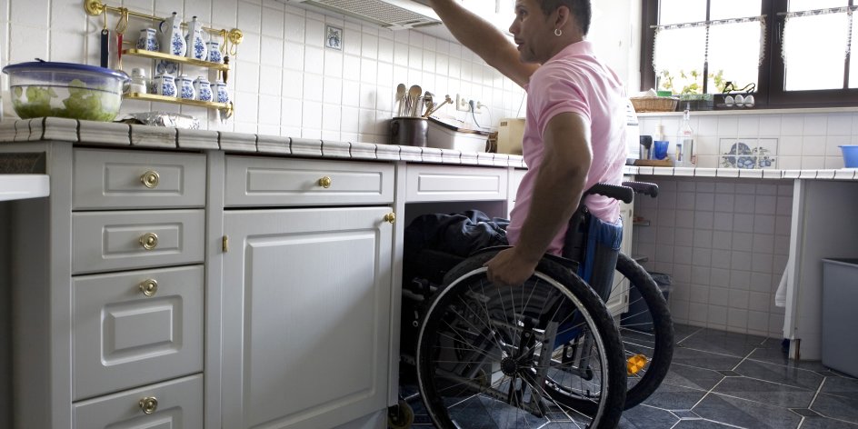Ein Mann im Rollstuhl in der Küche.