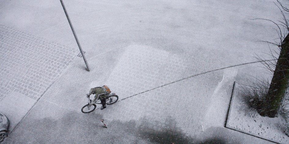 Radfahrer auf verschneiter Straße
