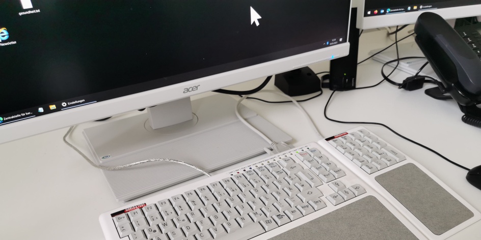 Ein Computerarbeitsplatz mit Monitor, Tastatur und Telefon. 