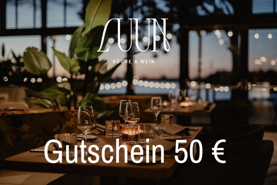 Ein Foto eines gedeckten Tischs im Restaurant Luun in abendlicher Stimmung mit der Bildaufschrift Luun Küche und Wein Gutschein 50 Euro