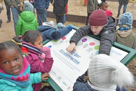Kinder entdecken die Schautafel zu Kinderrechten.