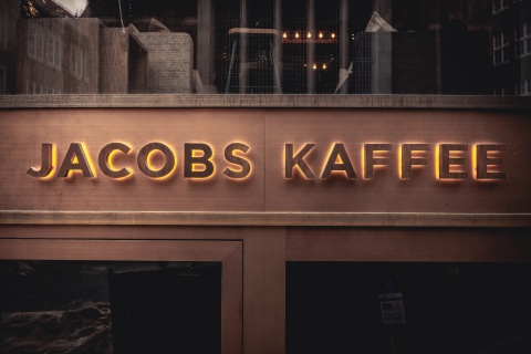 Der Schriftzug Jacobs Kaffee steht an einer brauen Hauswand.