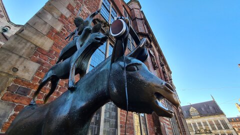 Der Esel der Statue der Bremer Stadtmusikanten trägt Kopfhörer. Darüber ist noch der Hund zu sehen