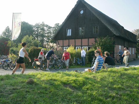 Strecke am Wümmedeich mit Radfahrern, Skatern und Rastenden an einem Fachwerkhaus