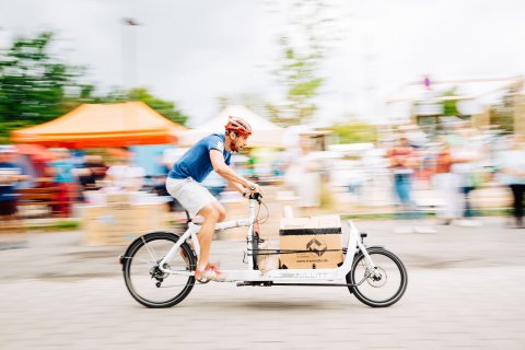Mann fährt mit dem Lastenrad