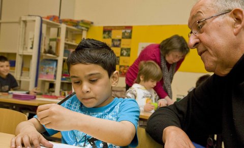 Ein Kind und ein älterer Mann über einer Mathe-Aufgabe; Quelle: Freiwilligen-Agentur Bremen/Susanne Frerichs