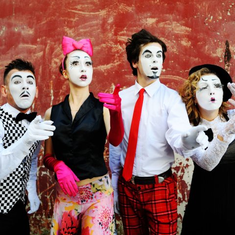 Zwei Schauspieler und zwei Schauspielerinnen mit schwarz-weiß geschminkten Gesichtern.