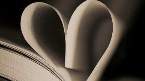 Ein aufgeschlagenes Buch, dessen obersten Seiten zu einem Herz geformt sind.
