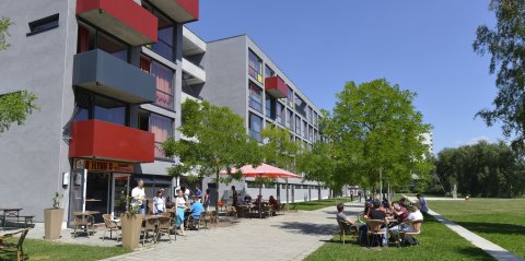 Studenten sitzen Draußen im Kaffee vor einem Studentenwohnheim an der Universität Bremen 