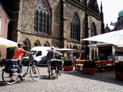 Zwei Radfahrer schieben ihr Rad durch die Bremer Innenstadt