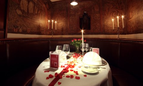 Ein schick gedeckter Tisch mit Rosen, Rosenblättern und Kerzen in einer Priölke im Bremer Ratskeller. Priölken sind kleine separate Ecken, die man im Bremer Ratskeller buchen kann, um dort zu essen oder zu trinken. 