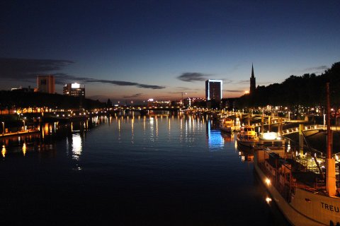 Blick auf die Weser an der Schlachte bei abendlicher Dunkelheit. Die Lichter spiegeln sich auf dem Wasser.