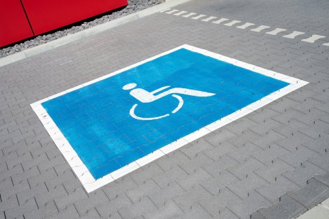 Ein aufgemaltes Rollstuhl-Symbol auf einem Behindertenparkplatz.