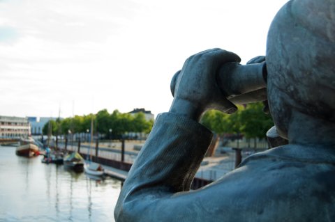 Statue mit Ferglas blickt auf den Hafen in Vegesack