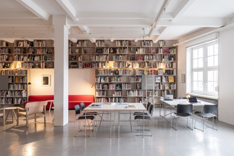 Abgebildet ist eine Bibliothek mit vielen Büchern.