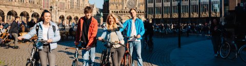 Junge Menschen schieben auf dem Bremer Marktplatz ihre Räder