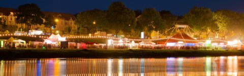 Blick auf festlich beleuchtete Festzelte zur Breminale an der Weser