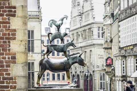 Die Statue der Bremer Stadtmusikanten schneebedeckt. 