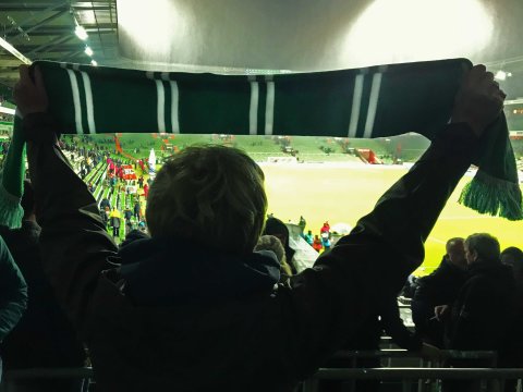 Eine Frau mit Werder-Schal in der Ostkurve des Weser-Stadions