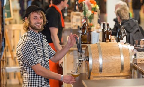 Ein junger Mann zapft Bier beim Craft Beer Event in der Messe Bremen.