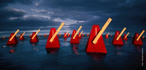 Mehrere rote Metronome im Wasser
