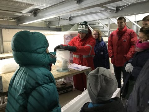 Eine Gruppe in Winterkleidung vor einer Eisprobe