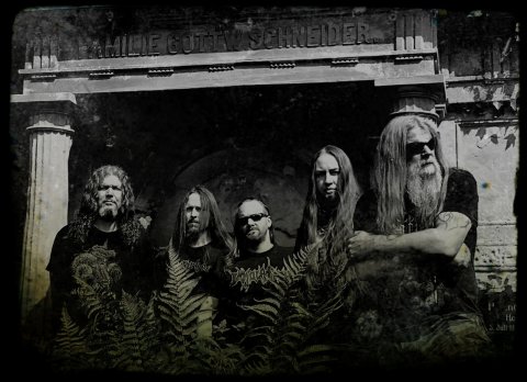 Die fünf Bandmitglieder stehen vor einem Krematorium und tragen Sonnenbrillen.