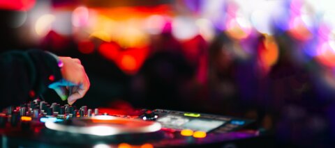 DJ booth and in the blurred background are dancing people.