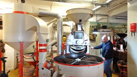 Ein Mann bedient eine große Maschine zum Rösten von Kaffee