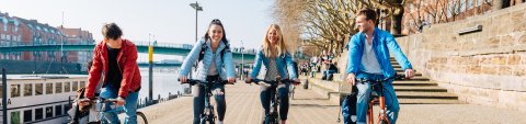Junge Menschen fahren an der Weser Fahrrad