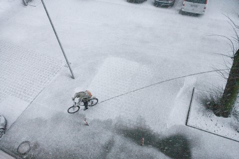 Blick von oben auf schneebedeckten Parkplatz mit Fahrradfahrer; Quelle: WFB/T. Vankann