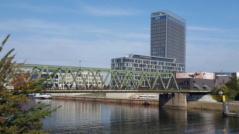 Der kleine Stadtmusikantenexpress vor den großen modernen Gebäuden der Bremer Überseestadt