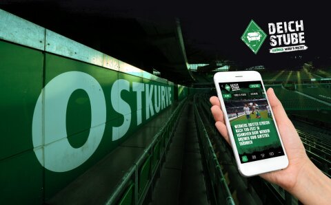 Stadionansicht der Ostkurve. Eine Hand hält ein Smartphone, auf dem die DeichStube-App zu sehen ist.