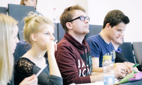 Studentinnen und Studenten sitzen in einer Vorlesung.