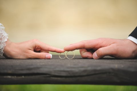 Ein Paar schiebt sich gegenseitig die Ringe zu