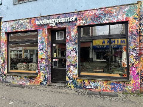 Außenansicht vom "Wohnzimmer" im Bremer Viertel. Die Wand ist mit einem bunten Graffiti besprüht. 