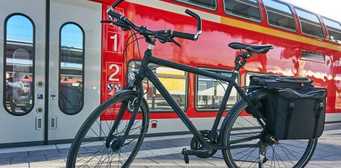 Ein Fahrrad steht vor einer Regionalbahn