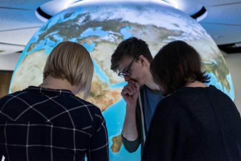 Drei Schüler vor einer Weltkugel im Klimahaus