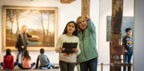 Zwei Mädchen betrachten etwas in einem Museum